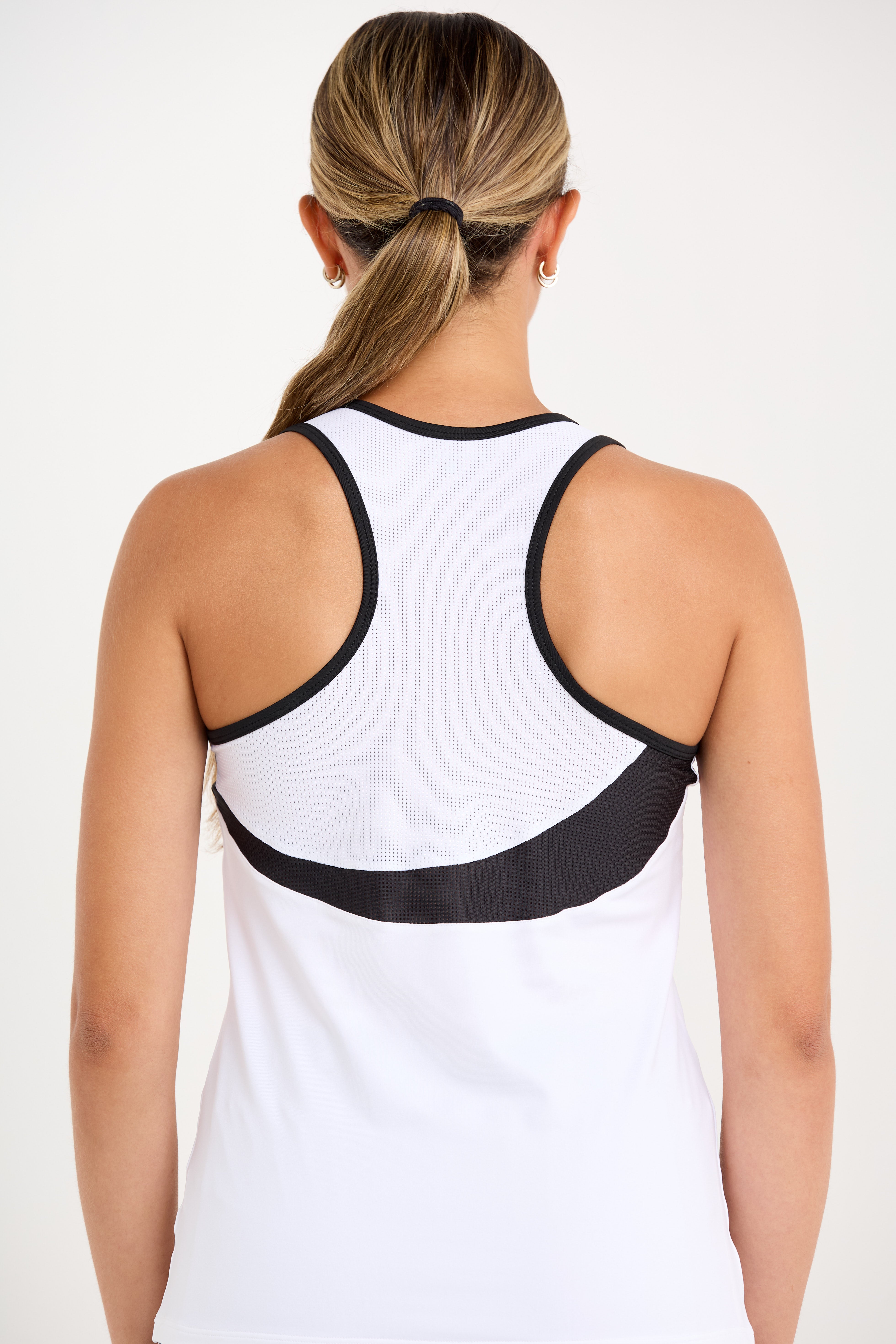 Monochrome women's tennis racerback top with mesh inserts, close up back view